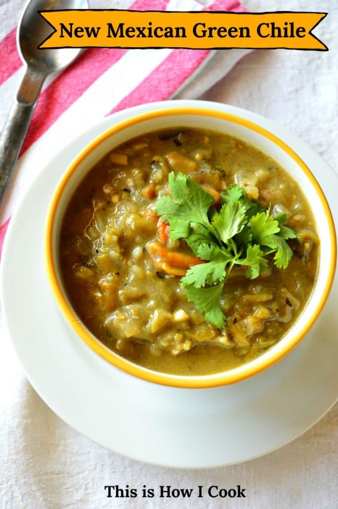 green chile sauce or soup in in yellow lined bowl with red and white striped napkin