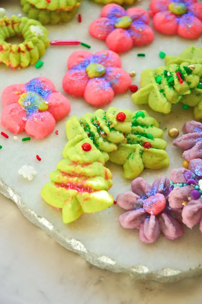 christmas spritz cookies recipe on white platter with gree, pink and ppurple colors