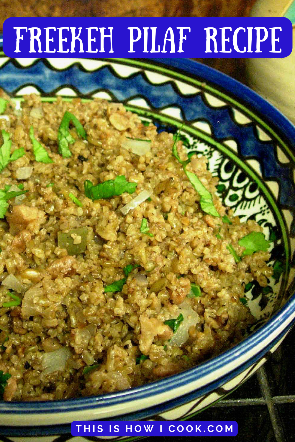 blue and white bowl filled with a cooked freekeh recipe and some green herbs cut on top.