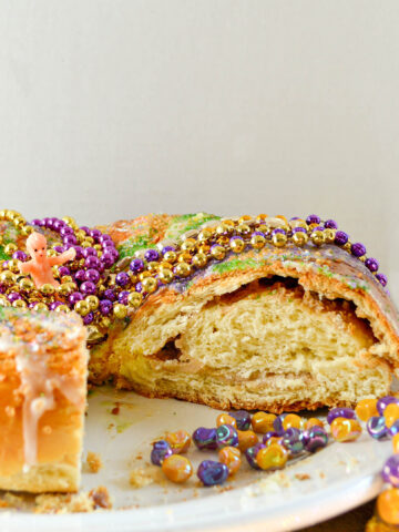 King Cake with cream cheese filling with colored sugar and mardi gras beads