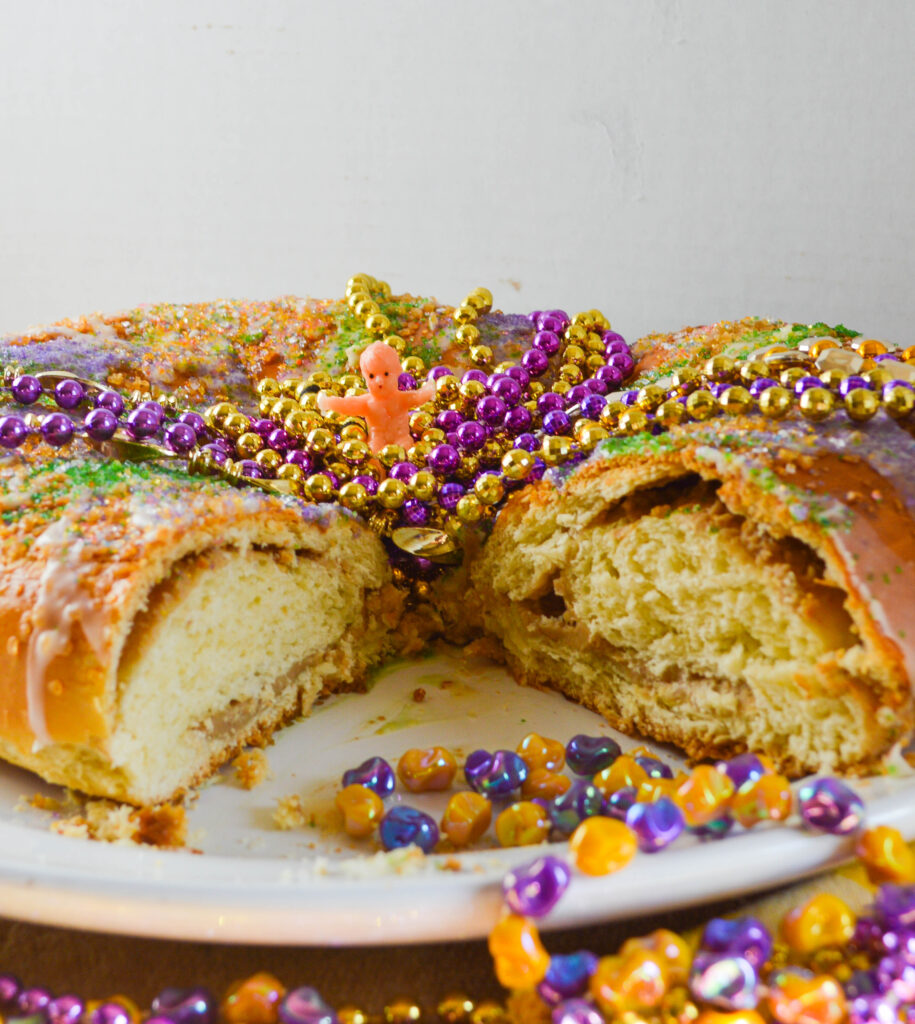 king cake with cream cheese filling and mardi gras beads