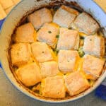 hoemmade chicken pot pie with bisccuits in Dutch oven