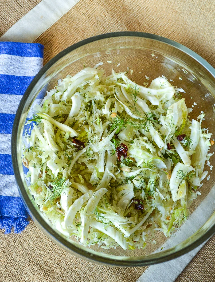 Cabbage Salad in clear glass bowl, blue napkin