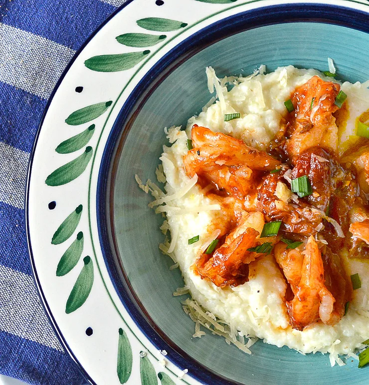 shrimp and grits with cheese in a white and green bowl