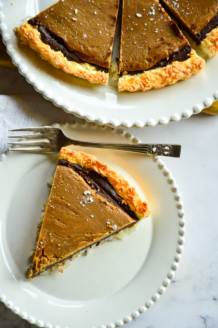 salted butterscotch tart in coconut crust on white plate