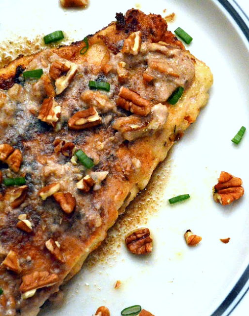 cajun fish with brown butter and pecans on plate.