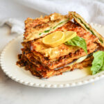 Matzo grilled cheese on white plate with basil and lemon