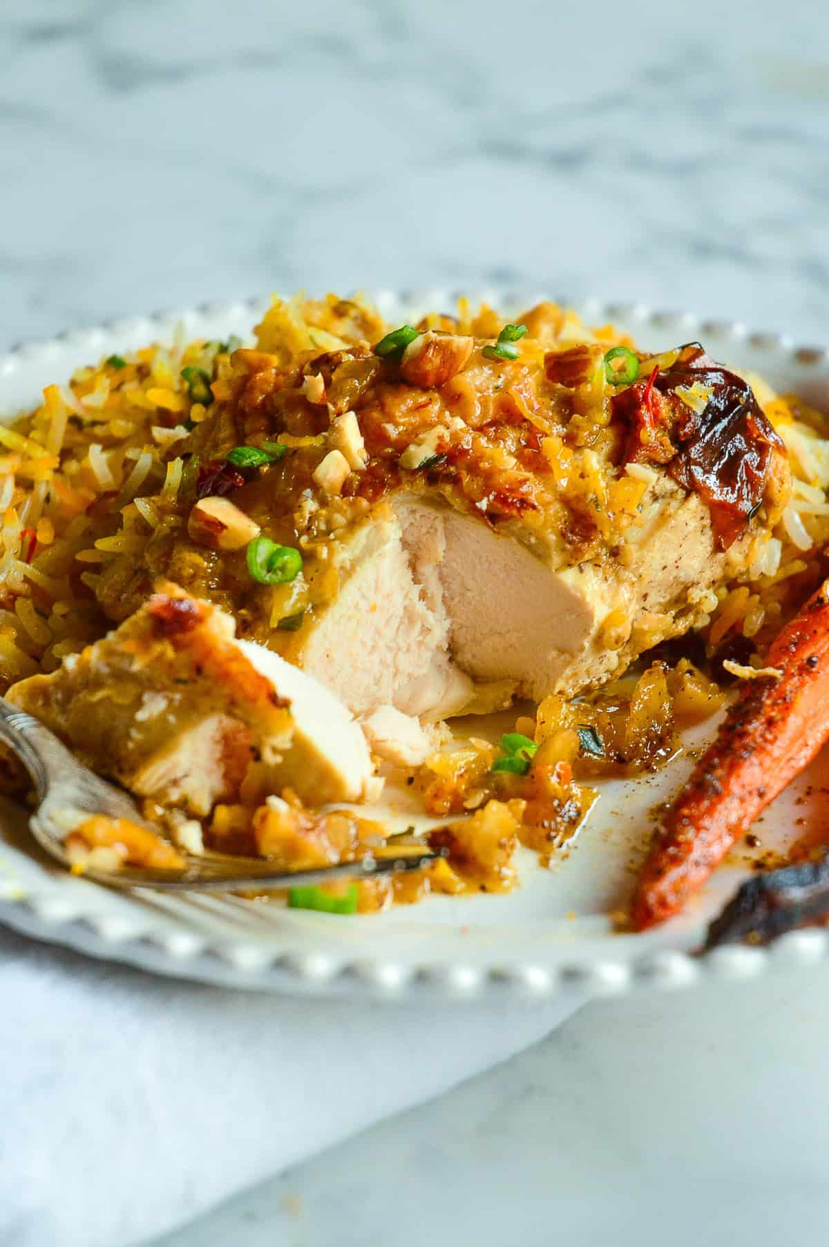 roasted chicken breast cut open with rice in background