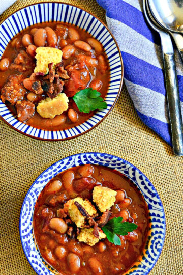 bean soup with sausage in blue and white bowls with blue napkin