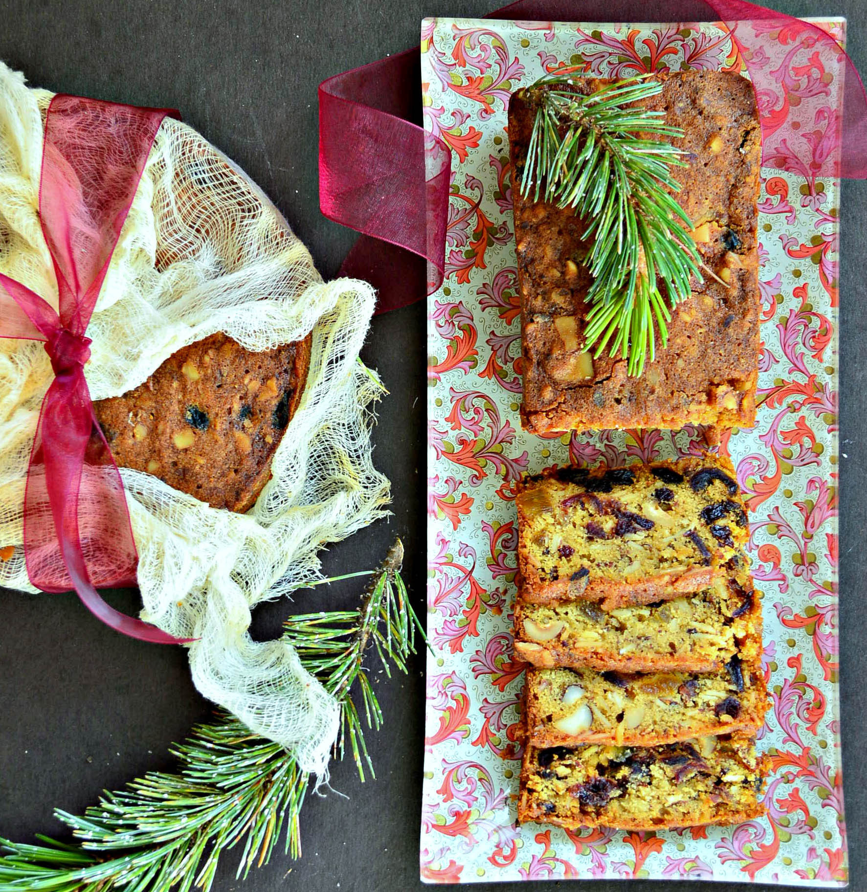 Rum Fruit Cake Recipe on decoupage plate with one wrapped in cheesecloth