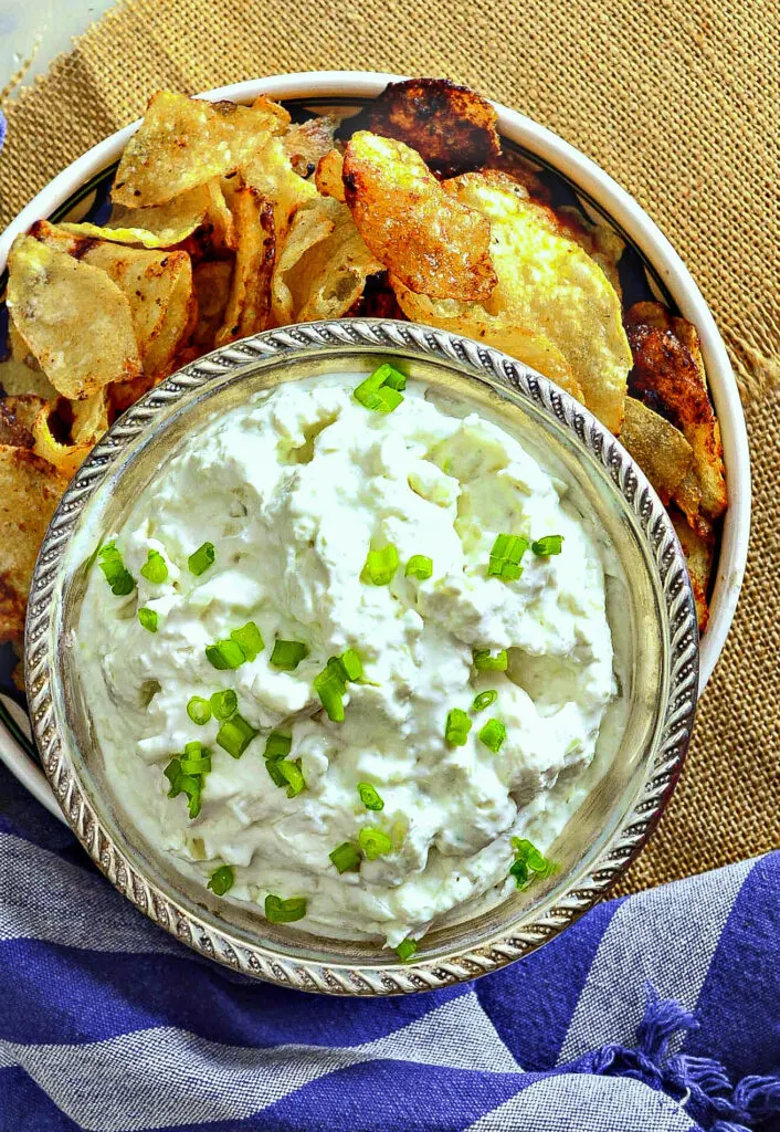 cream cheese onion dip in silver bowl with potato chips