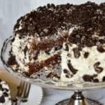 oreo cake on silver cake stand with slice out of it