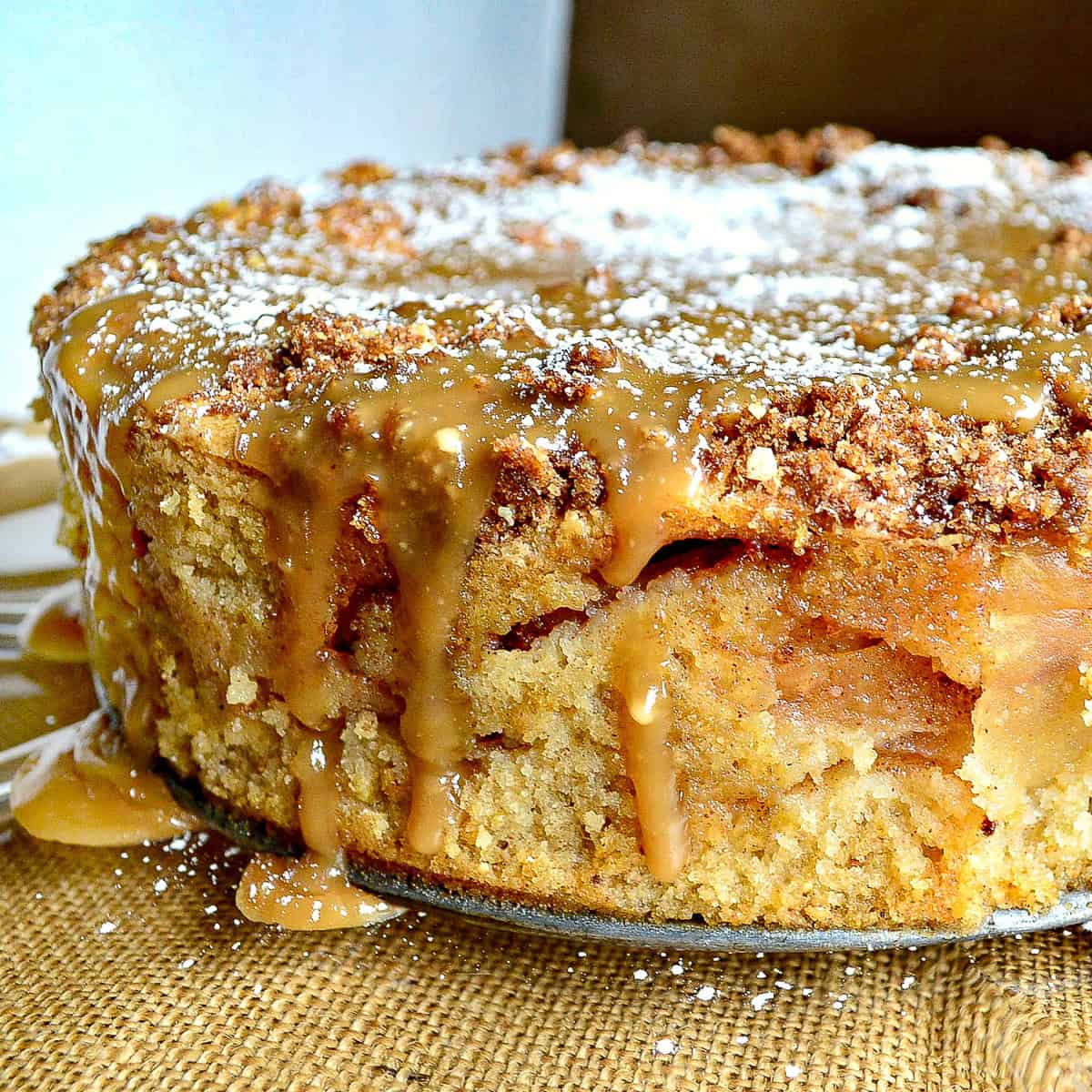 Passover apple cake with streusel and caramel sauce on glass platter