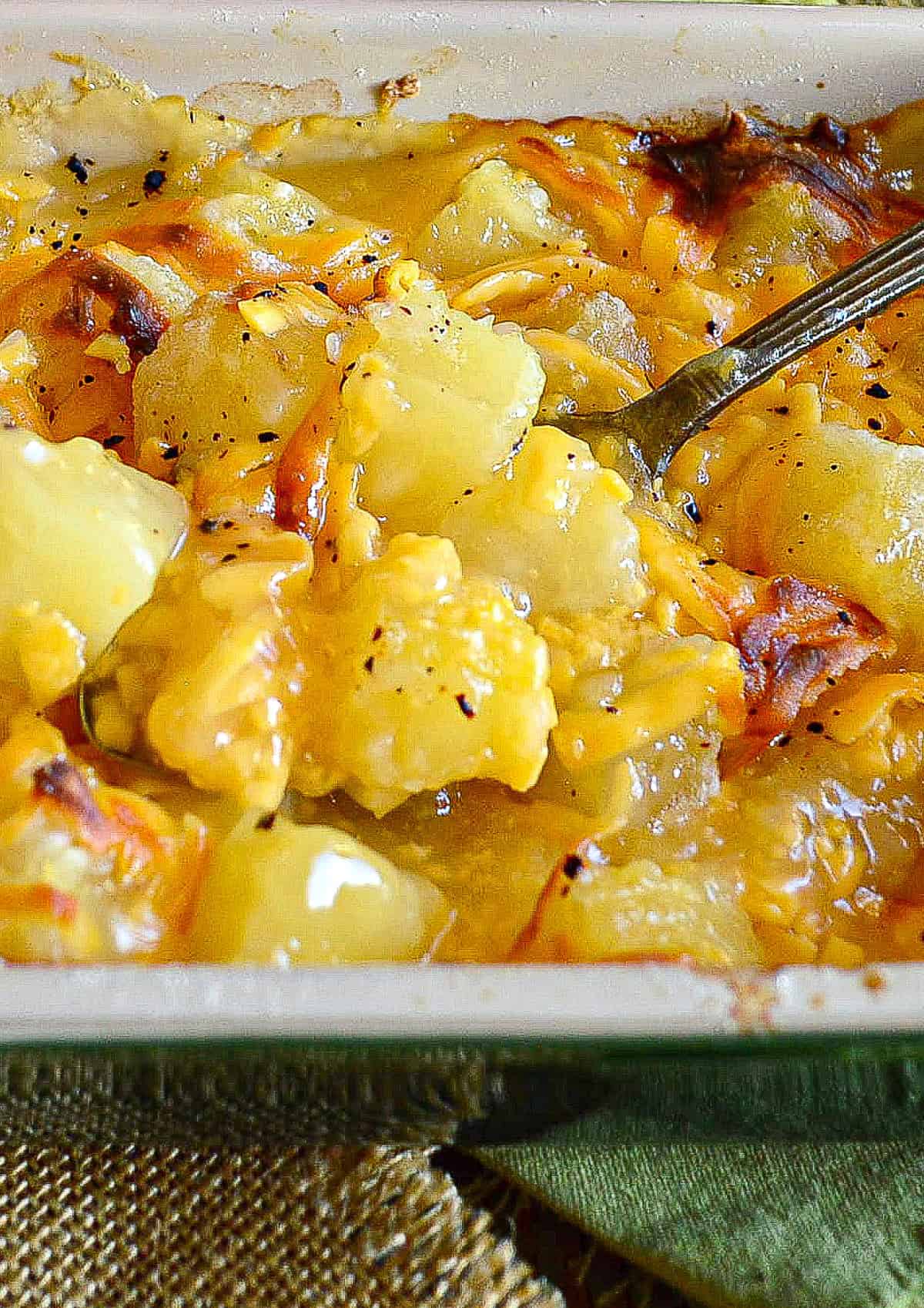 This easy, cheesy pineapple bake has just 4 ingredients. It is simple and delicious and we've been making it for about 40 years! #pineapple #casserole www.thisishowicook.com close up of pineapple bake in casserole dish