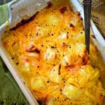 pineapple bake with cheese in green casserole dish with spoon