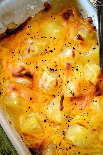 pineapple bake with cheese in green casserole dish with spoon