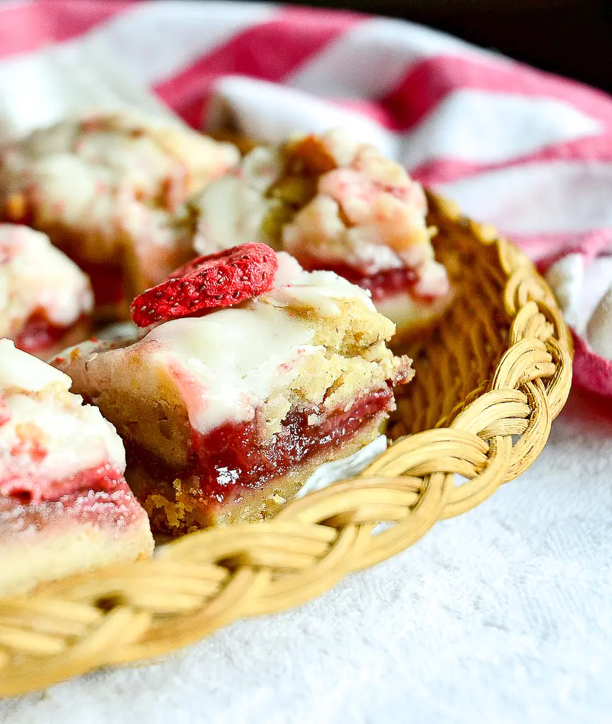 strawberry crumble bars on wicker plate