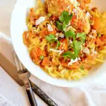 Aji Coconut Chicken in white bowl with noodles