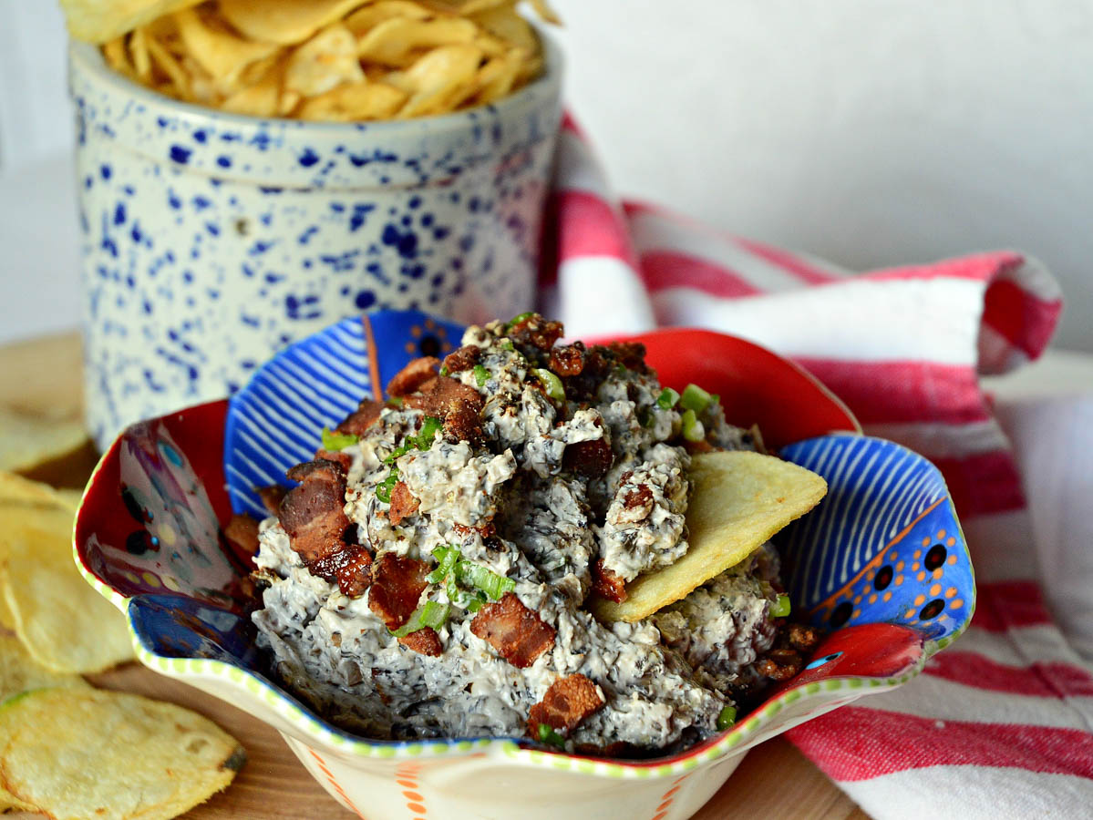 bacon mushroom dip in red and blue bowl with red stripe napkin and potato chips