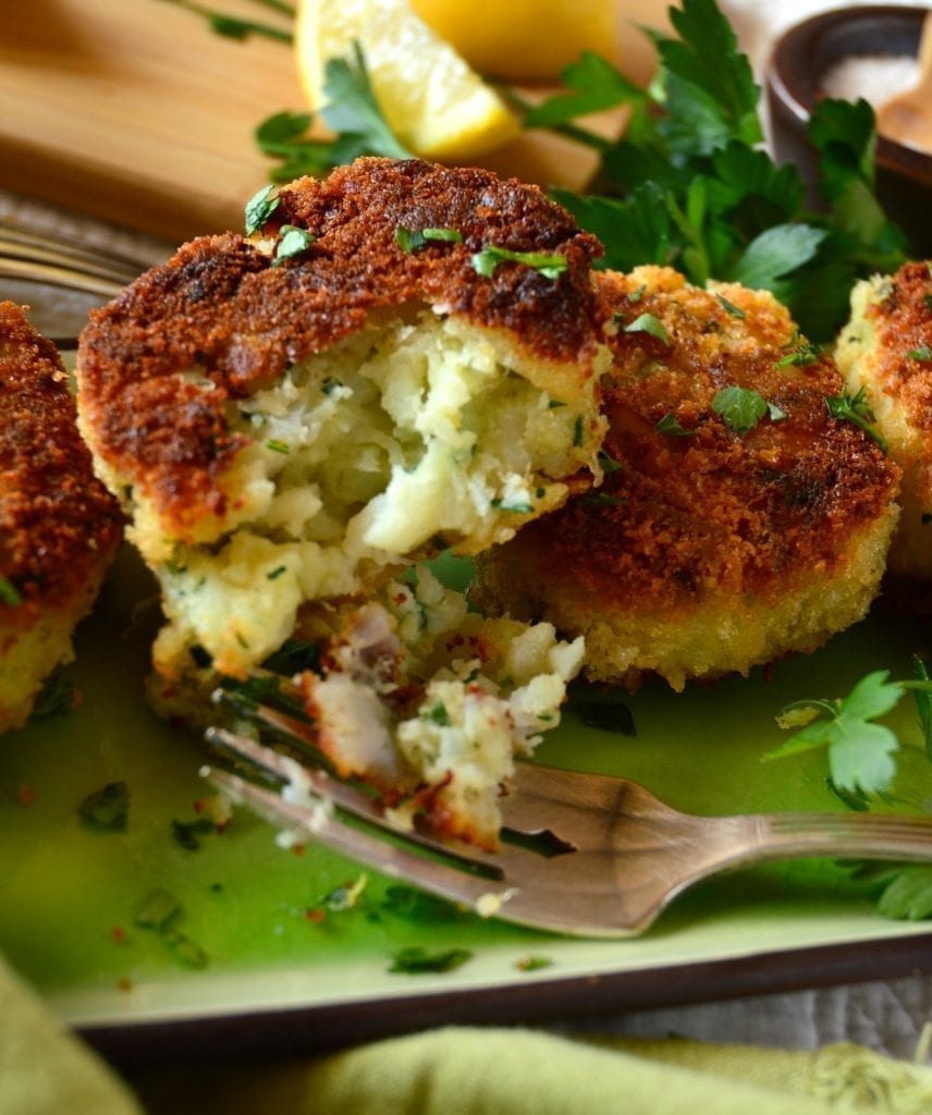Irish Fish Cakes are savory cakes made with milk simmered cod and mashed potatoes. One might think these are entirely made of fish because of their flakey soft interiors. Topped with a simply homemade tartar sauce, these are a winner in my book! #seafood #Irishfood #fishcakes #tartarsauce www.thisishowicook.com