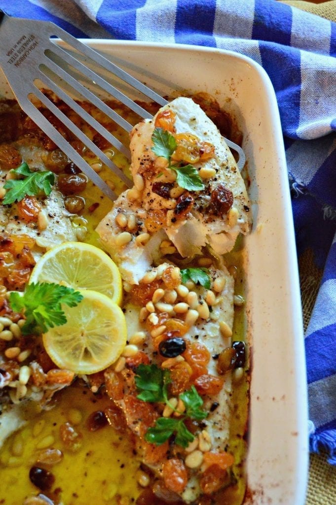 This red snapper fillet is baked in a bed of olive oil and topped with pine nuts, raisins and a sprinkle of black pepper. Ready to go into the oven in 5 minutes, which leaves time to make rice and salad! #fish #seafood #quickmeals www.thisishowicook.com