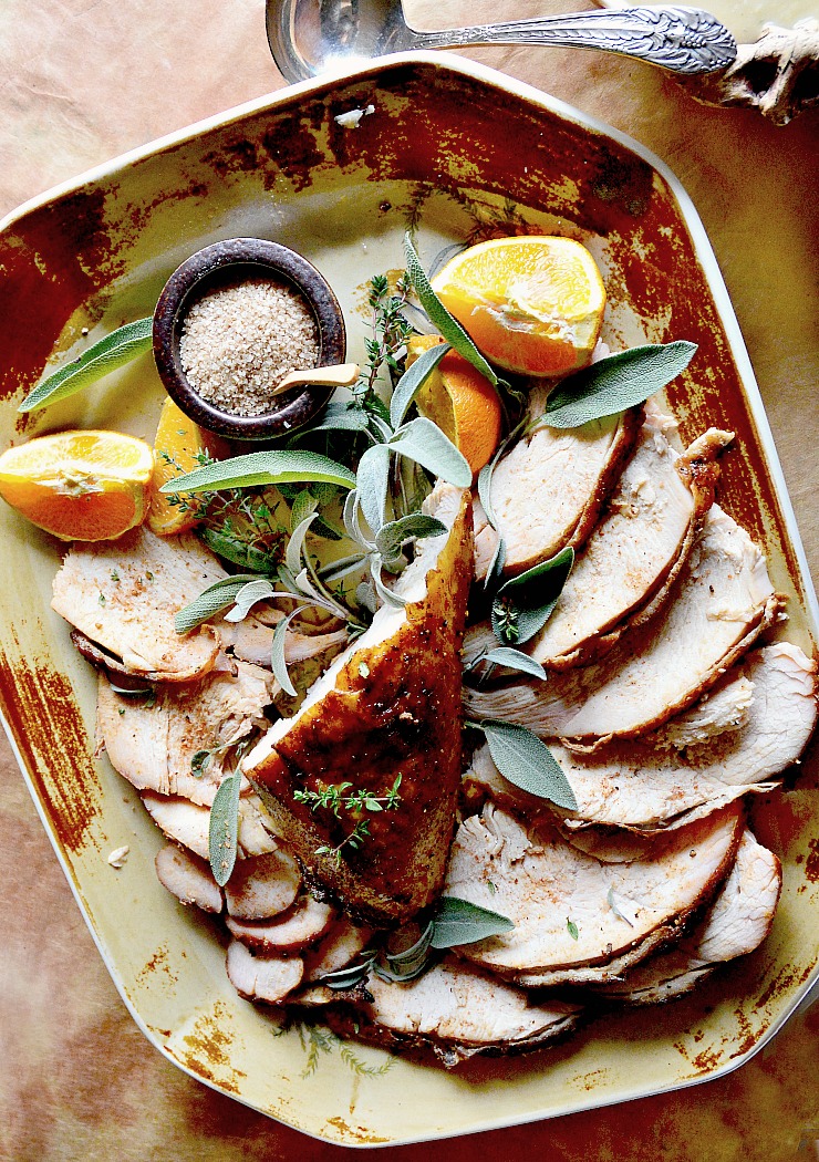 whiskey glazed turkey breast on ceramic platter with oranges