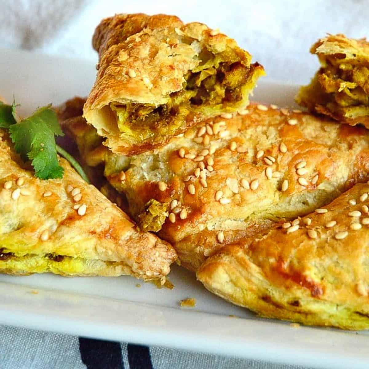 chicken curry puffs shaped as triangles on white plate