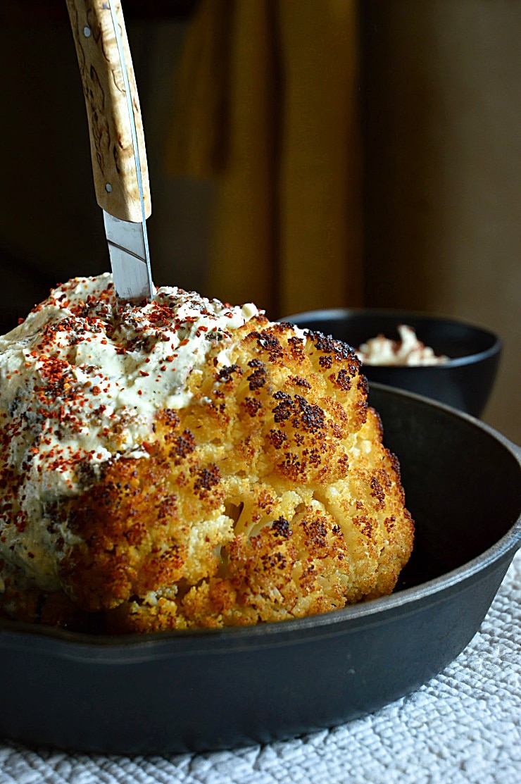 Whole Roasted Cauliflower with Cheese in a Cast Iron Skillet on top ten