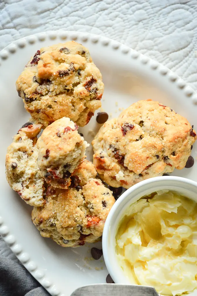 Cranberry Cherry Chocolate Scones on white dish with butter