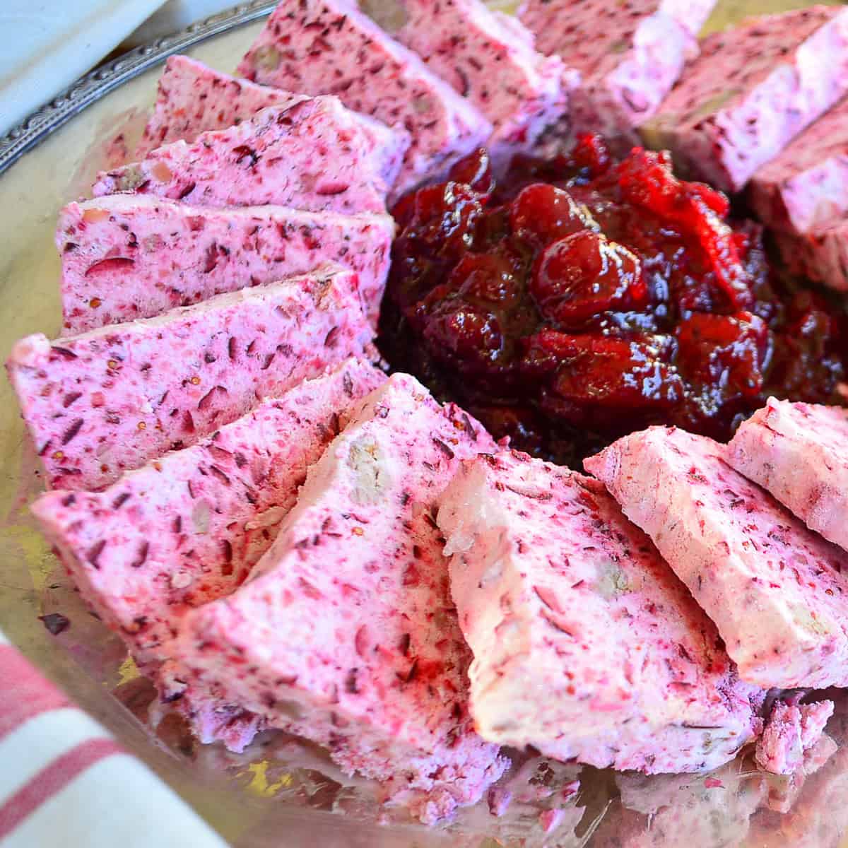 frozen cranberry salad on silver platter with berry cranberries in the middle