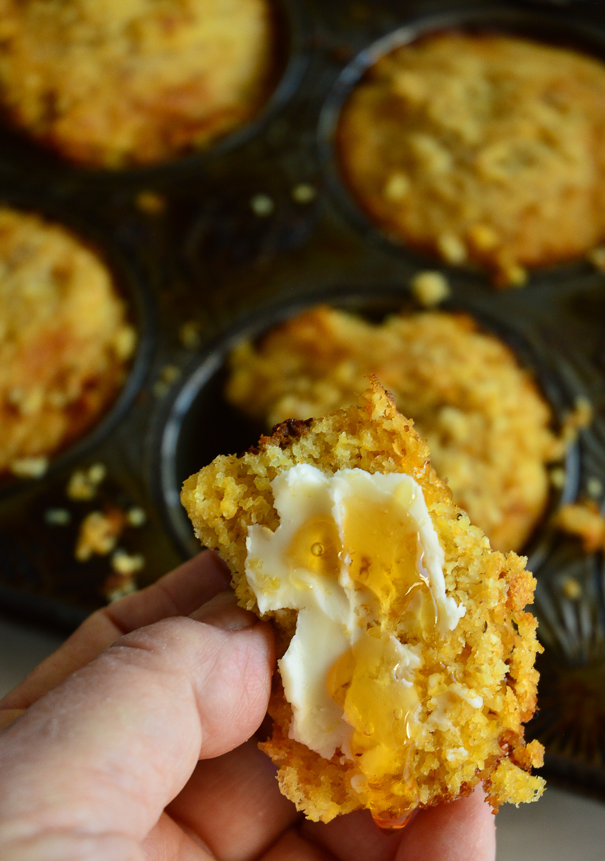 half of glutenfree cornbread muffin spread with honey and butter