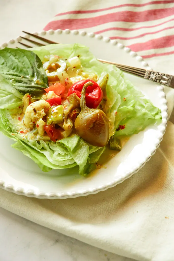 Iceberg lettuce salad on white plate with red stripe towel