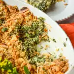 spinach casserole recipe in white oval baker and served on a white plate