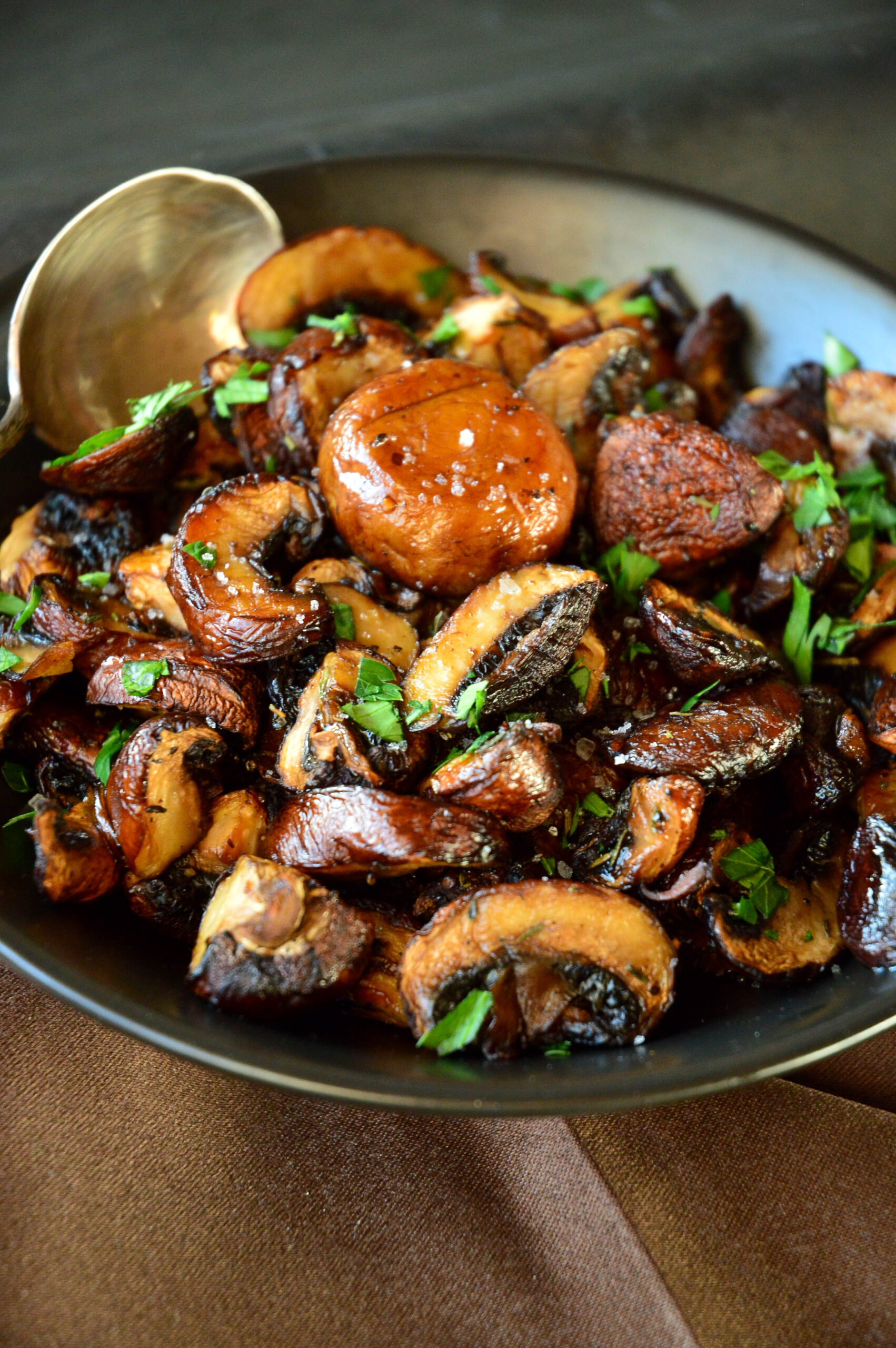 Roasted portabello mushrooms recipe in black bowl with spoon