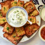 sheet pan latkes on platter with sour cream, blue napkin,