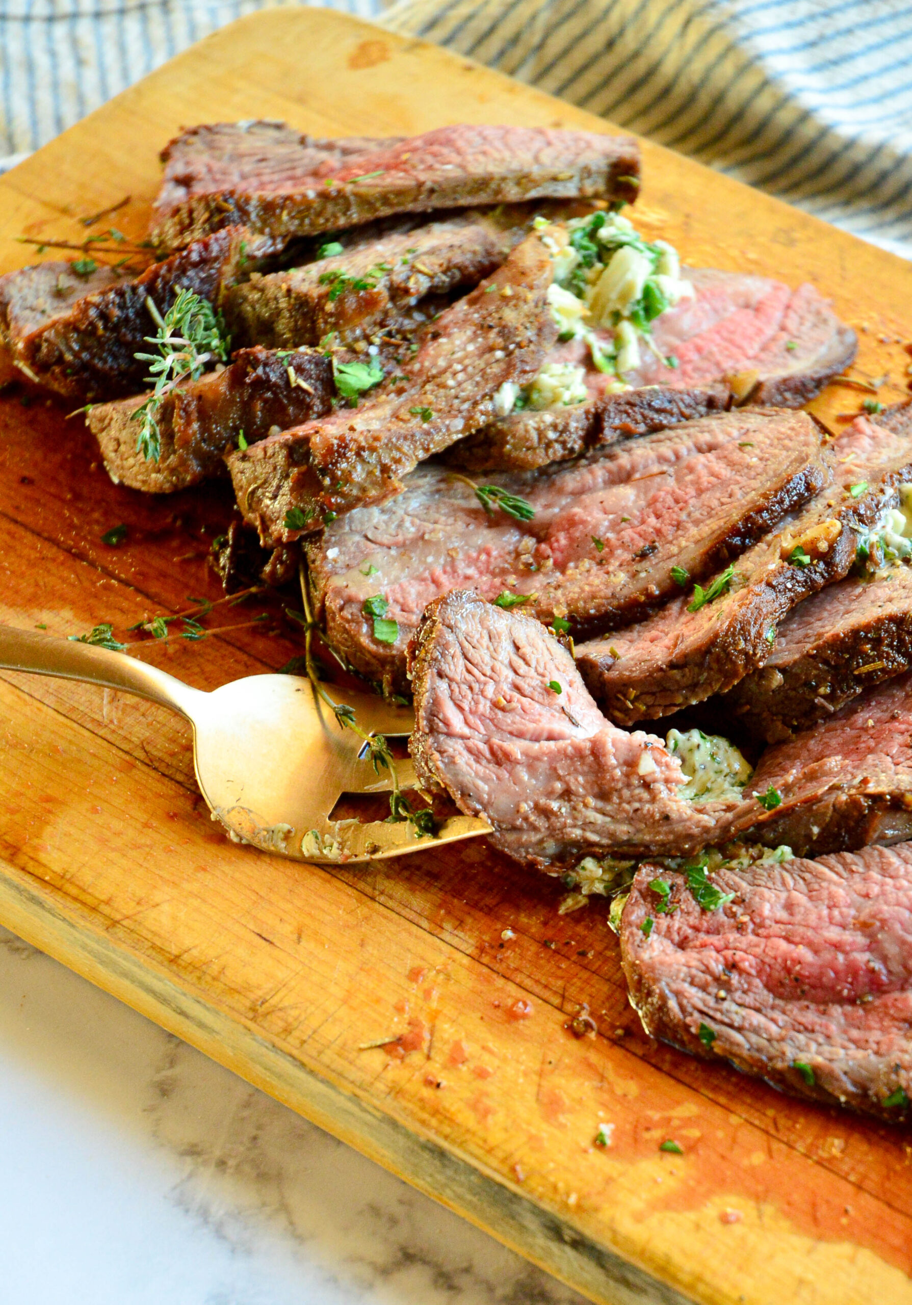 skillet to oven tri tip roast on cutting board with serving fork
