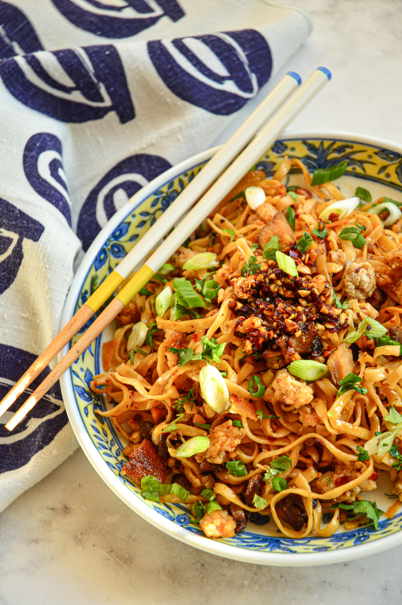 spicy chili garlic noodles recipe in blue dish with chopsticks