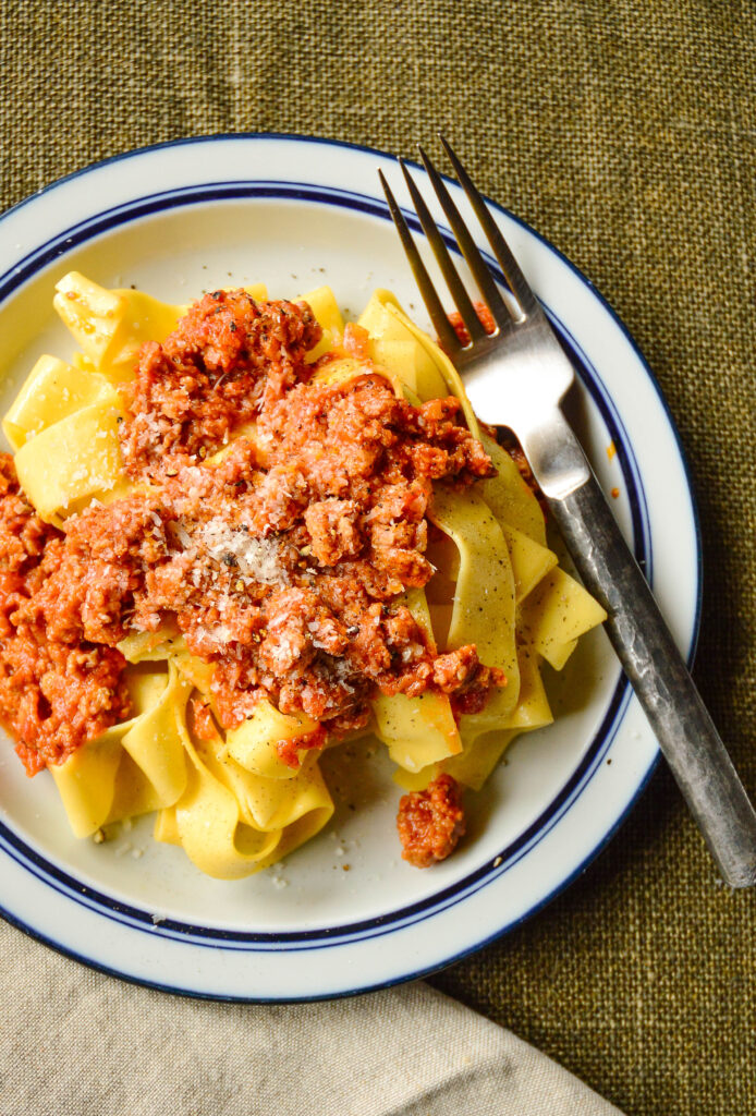 Giada's Bolognese sauce recipe over pasta on white plate