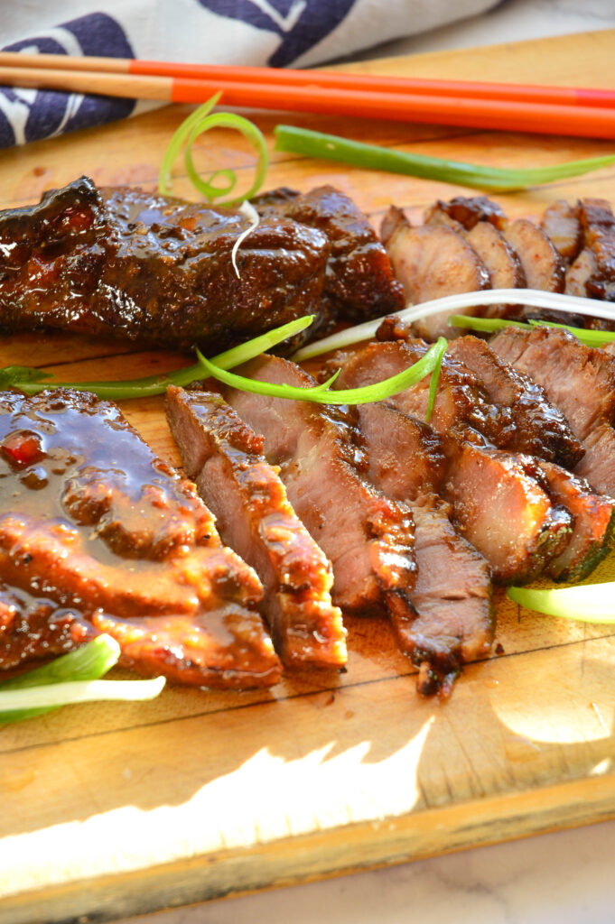  Char Siu Chinese Barbeque Pork Recipe on cutting board with chopsticks and blue napkin