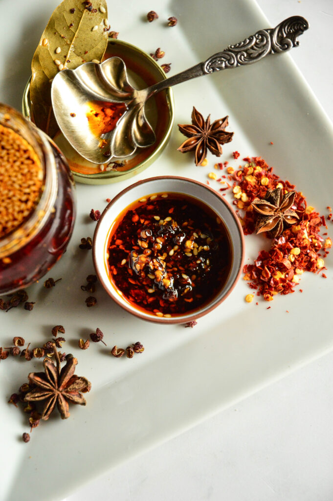 Chinese Chili garlic sauce recipe with chili flakes, spoon, bay leaf, chili oil