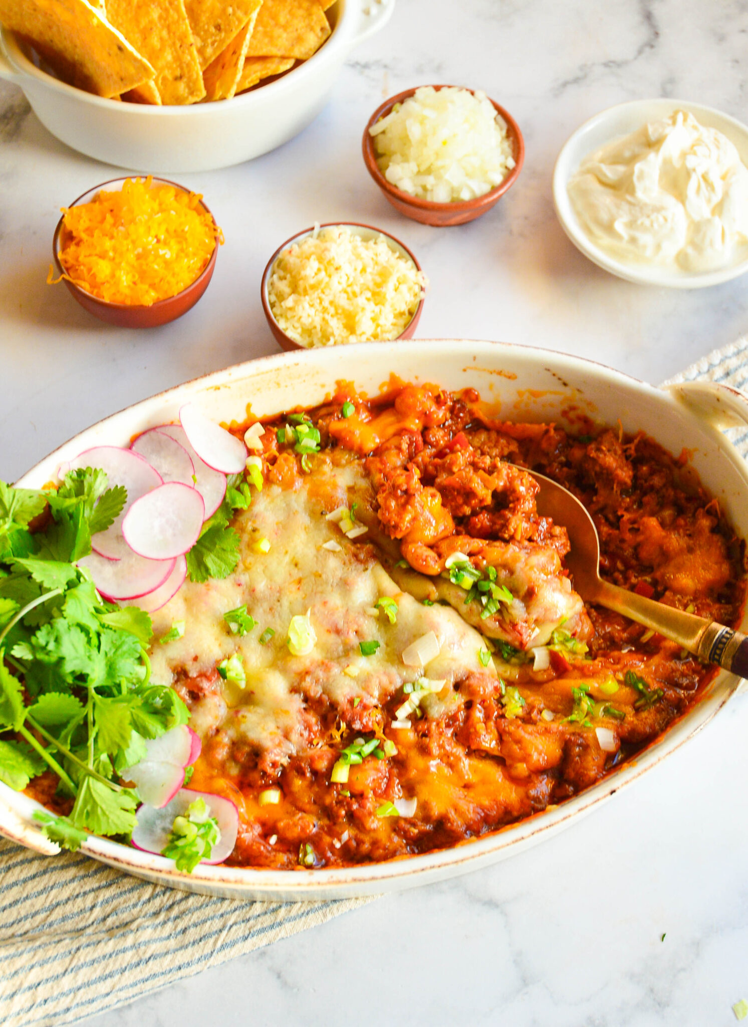 chicken taco casserole recipe in baking dish with tortilla chips