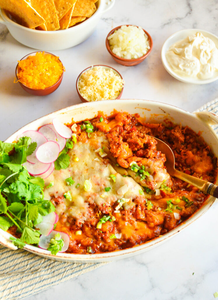 chicken taco casserole in caking dish with tortilla chips