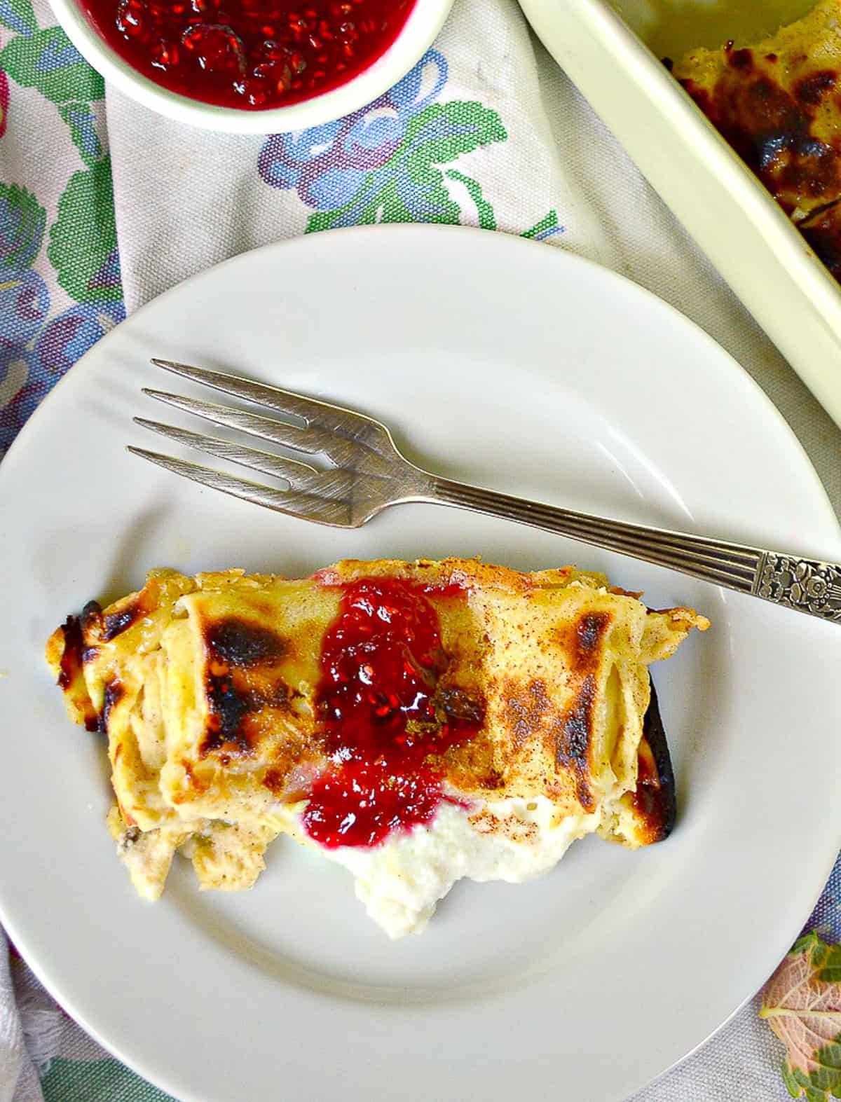 Single Blintz with red jam and fork