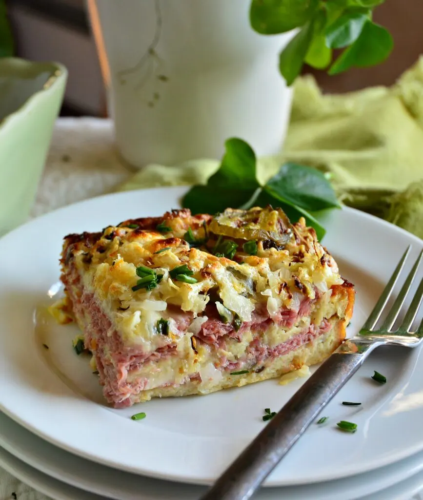 Overnight Reuben Strata cut into a square on a white plate