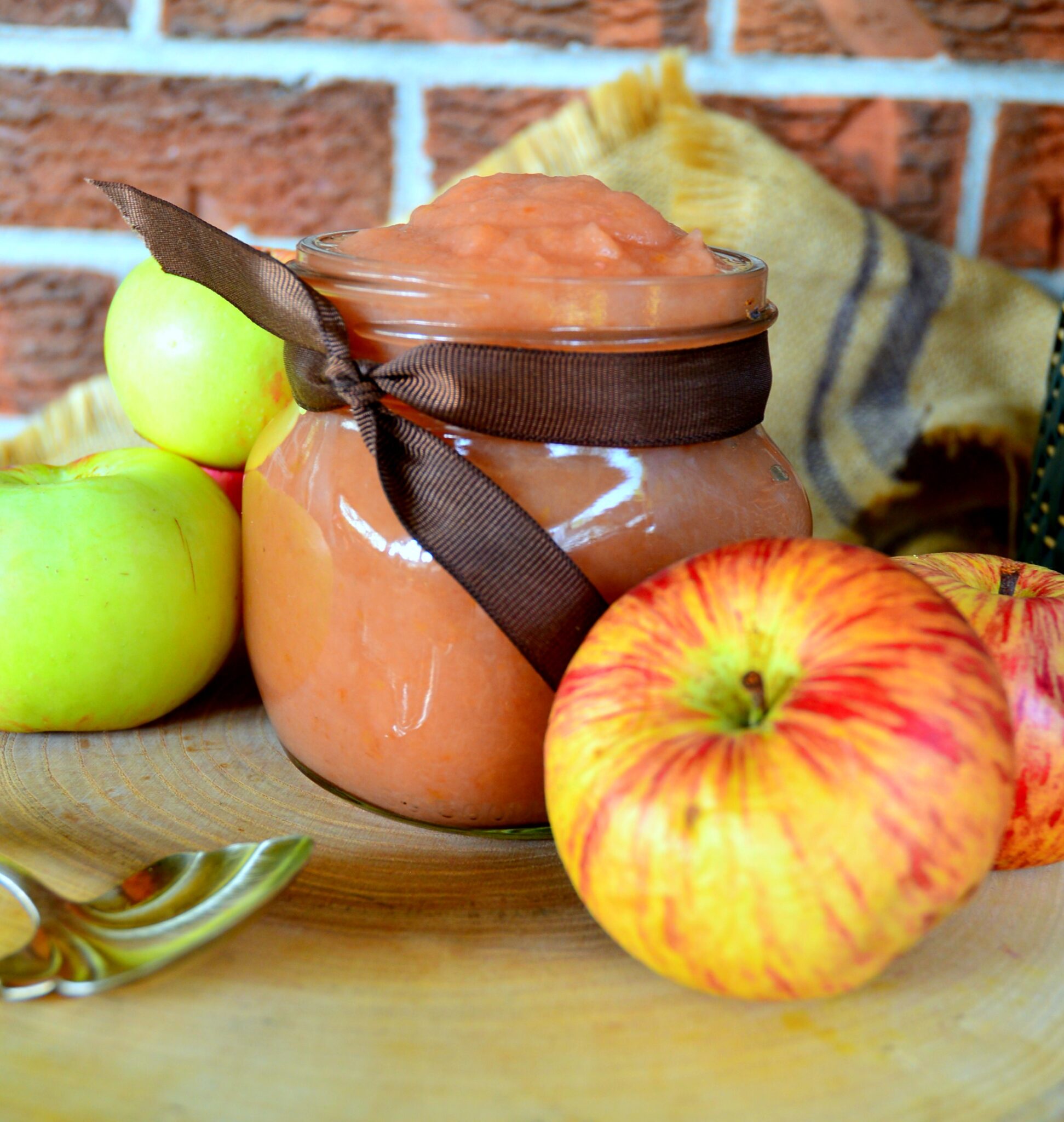 mom's cinnamon applesauce in jar with ribbon and apples
