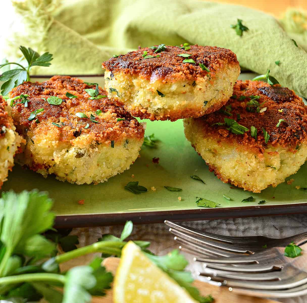 three irish fish cakes on green tray with forks