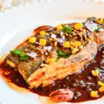 pan fried rainbow trout recipe with red chili on white plate