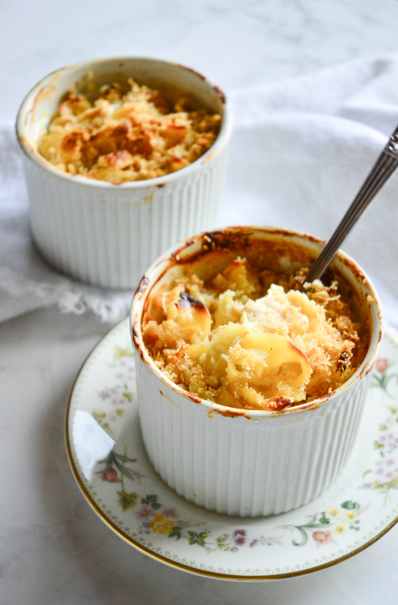individual sweet noodle kugel recipe in white souffle dish on floral round plate