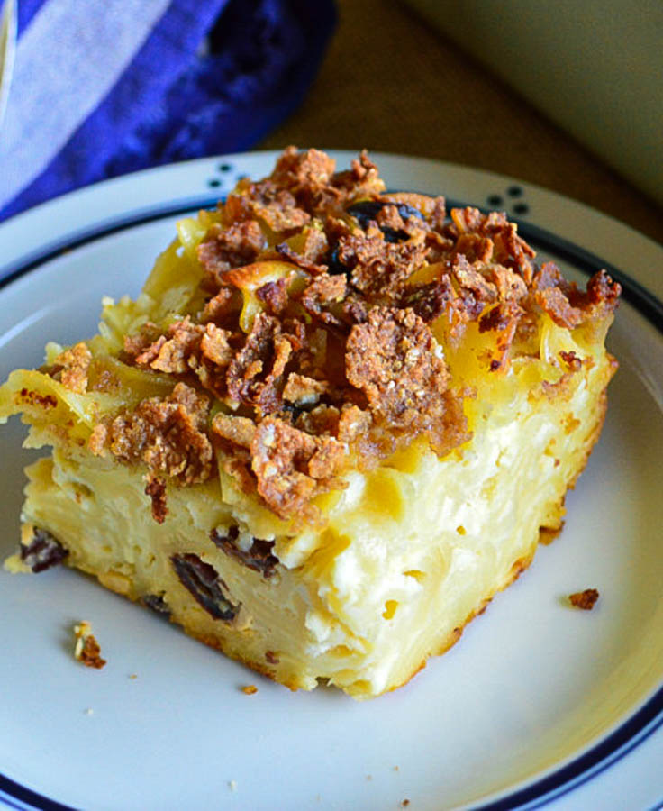 Jewish noodle kugel with raisins on ropund blue striped plate