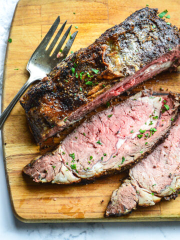 how to cook a boneless ribeye sliced on cutting board